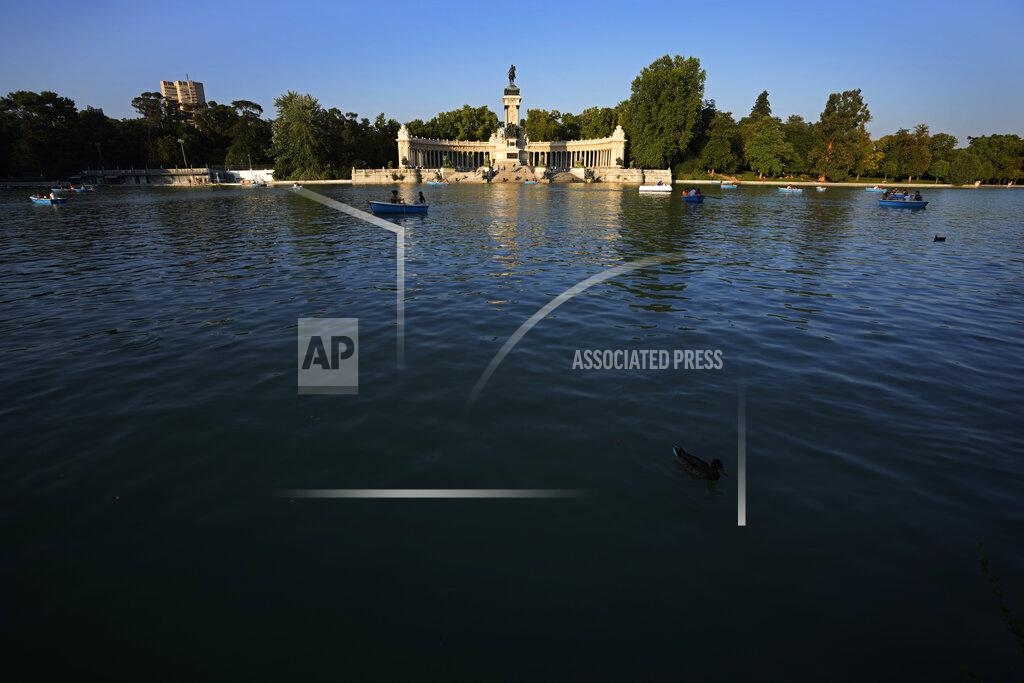 Paul White People row pleasure boats in the lake in front of the monument to King Alfonso XII in the Retiro park in Madrid, Spain, Friday, July 23, 2021. Madrid's tree-lined Paseo del Prado boulevard and the adjoining Retiro park have been added to UNESCO's World Heritage list. The UNESCO World Heritage Committee backed the candidacy that highlighted the green area's introduction of nature into Spain's capital. (AP Photo/Paul White)