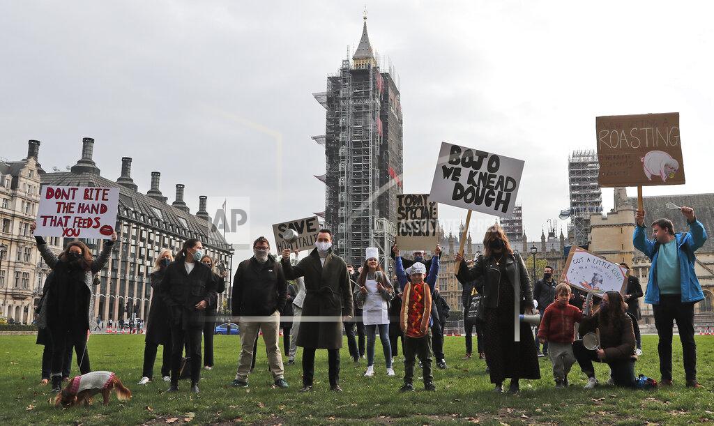 Hospitality workers protest in Parliament Square in London, Monday, Oct. 19, 2020. Hospitality workers are demonstrating outside Parliament against tougher coronavirus restrictions and the amount of financial support given by the government to the industry.(AP Photo/Frank Augstein)