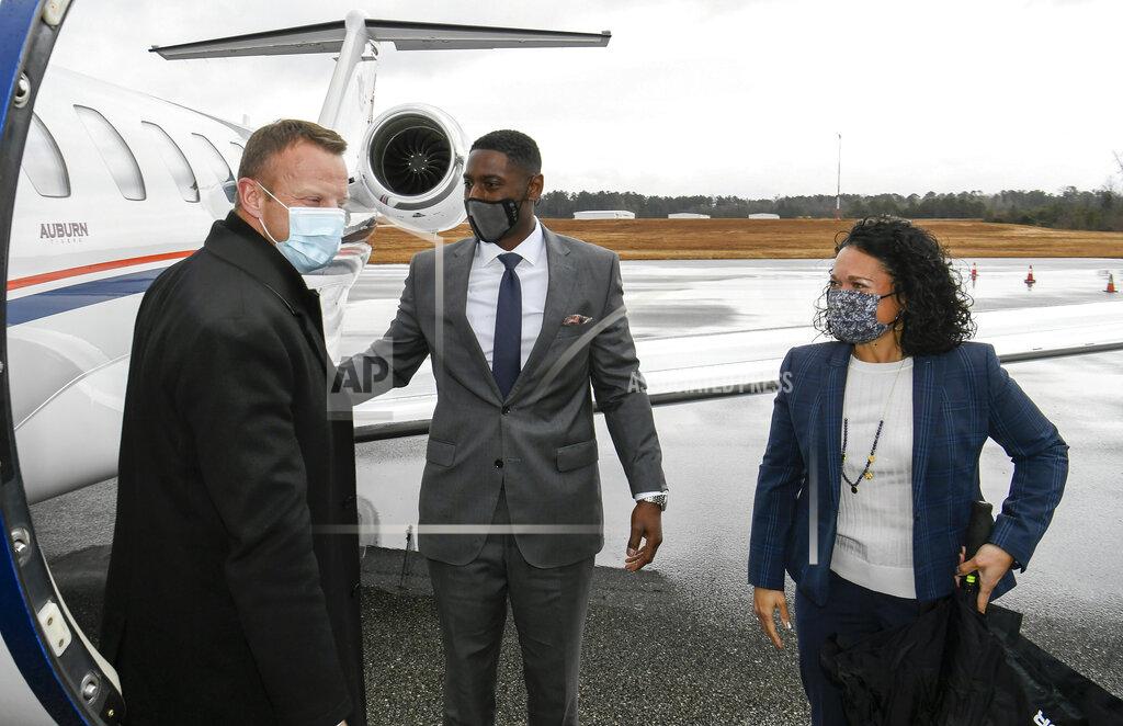 Todd Van Emst In this photo provided by Auburn Athletics, Bryan Harsin, left, Auburn's new football coach, is greeted by Auburn athletic director Allen Greene and his wife, Christy Greene, Thursday, Dec. 24, 2020, in Auburn, Ala. (Todd Van Emst/Auburn Athletics via AP)