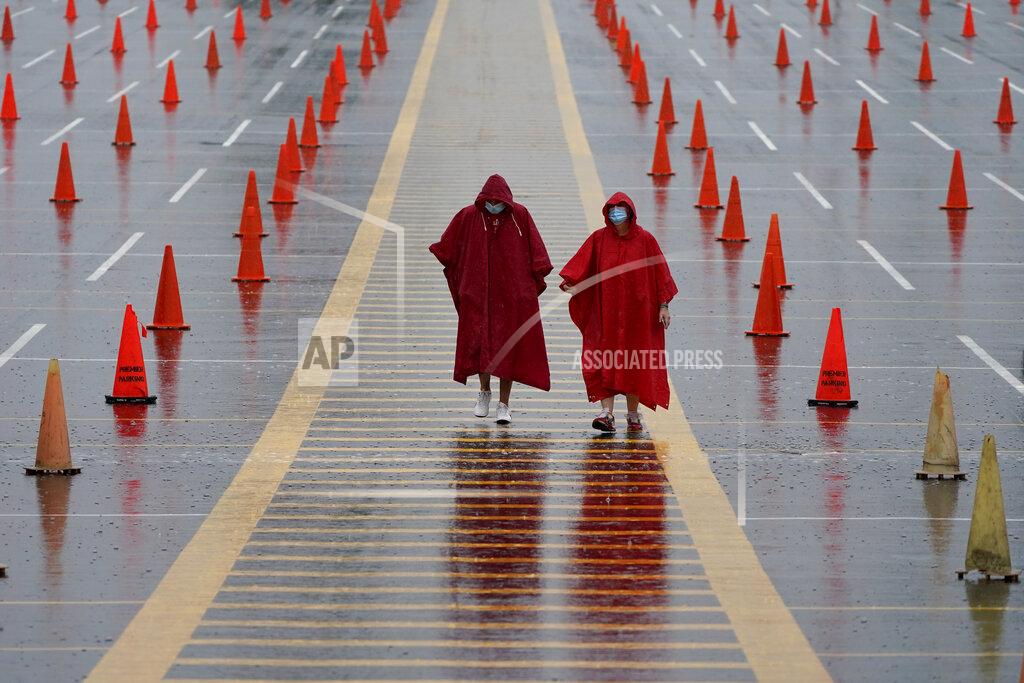 Charlie Riedel FILE - In this Aug. 29, 2020, file photo, fans walk through a parking lot at Arrowhead Stadium marked with traffic cones to keep fans from parking too close together during NFL football training camp for the Kansas City Chiefs in Kansas City, Mo. A football-starved nation is getting its games back with the start of the NFL season, but many worry that attending games or get-togethers will lead to a new surge in coronavirus infections. NFL football will kick off Thursday, Sept. 10, in Kansas City at a stadium that's allowing 17,000 fans inside. (AP Photo/Charlie Riedel, File)