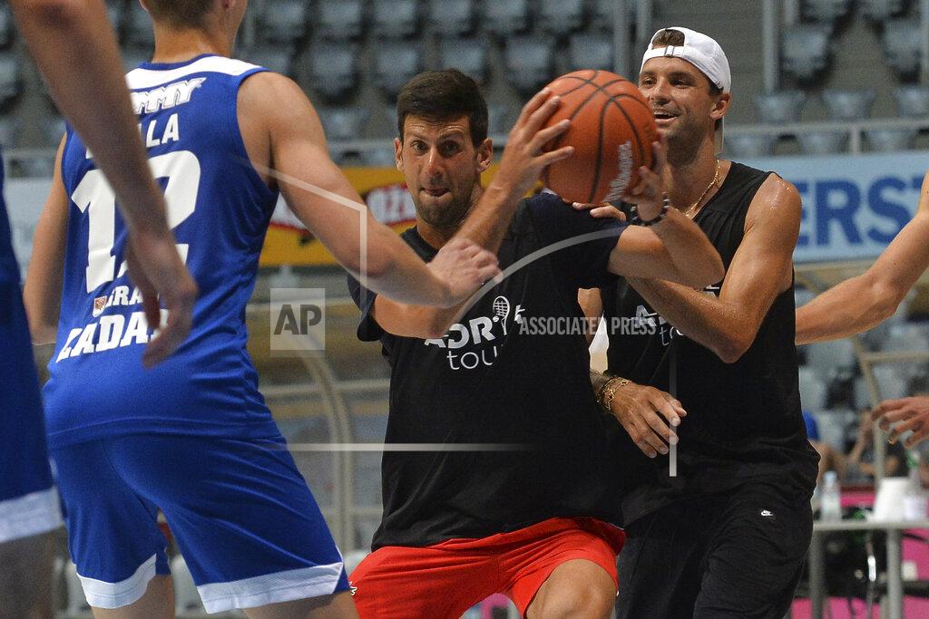 Zvonko Kucelin In this photo taken June 18, 2020, Serbian tennis player Novak Djokovic, center, plays basketball with Bulgarian tennis player Grigor Dimitrov, right, in Zadar, Croatia. Novak Djokovic has tested positive for the coronavirus after taking part in a tennis exhibition series he organized in Serbia and Croatia. (AP Photo/Zvonko Kucelin)