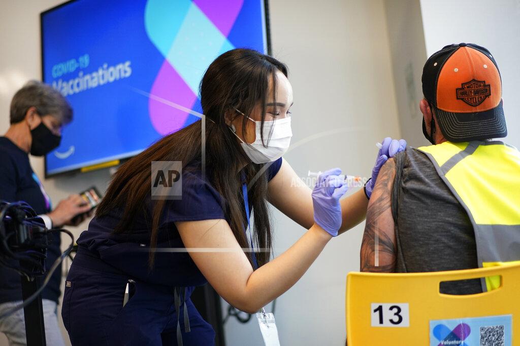 John Locher Registered nurse Sofia Mercado administers a vaccine shot at a vaccination event for workers at an Amazon Fulfillment Center, Wednesday, March 31, 2021, in North Las Vegas, Nev. A growing number of companies and labor unions are directly securing coronavirus vaccines for their workers. Amazon and some other large companies have hosted on-site inoculations, while smaller operations have helped book appointments for their workers. (AP Photo/John Locher)