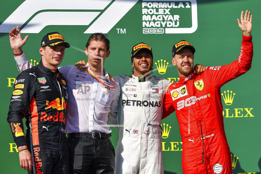 Zsolt Czegledi From left, second placed Dutch Formula One driver Max Verstappen of Red Bull, Chief Strategist of Mercedes team James Vowles, winner British Lewis Hamilton of Mercedes and third placed German Sebastian Vettel of Ferrari celebrate on the podium during the award ceremony of the Hungarian Formula One Grand Prix at the Hungaroring circuit, in Mogyorod, Hungary, Sunday, Aug. 4, 2019. (Zsolt Czegledi/MTI via AP)