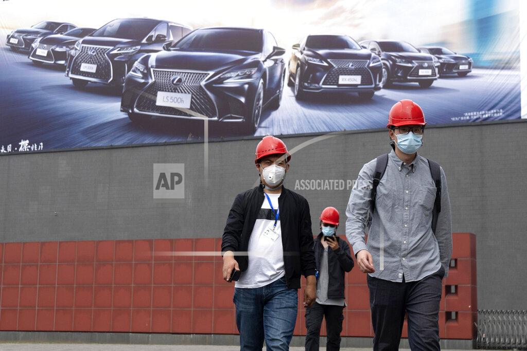 Ng Han Guan Workers prepare for the upcoming Auto China 2020 show in Beijing on Thursday, Sept. 24, 2020. Auto executives are flying in early to wait out a coronavirus quarantine ahead of the Beijing auto show, the year's biggest sales event for a global industry that is struggling with tumbling sales and layoffs. (AP Photo/Ng Han Guan)