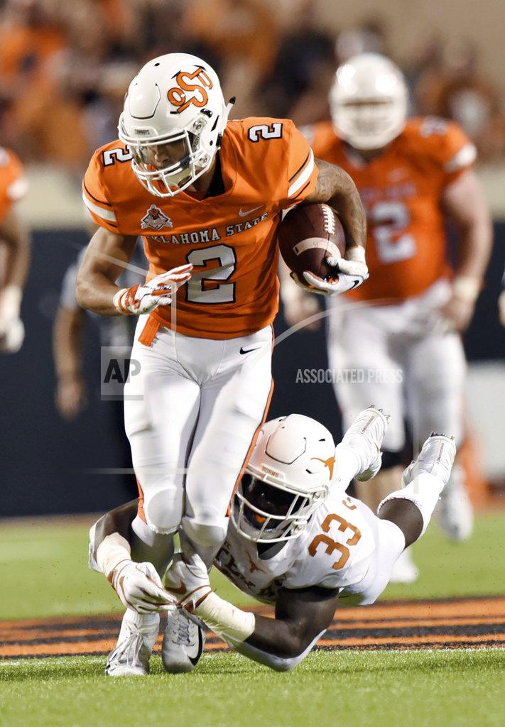 Brody Schmidt Texas linebacker Gary Johnson (33) tackles Oklahoma State wide receiver Tylan Wallace (2) in the second half of an NCAA college football game in Stillwater, Okla., Saturday, Oct. 27, 2018. Oklahoma State defeated Texas 38-35. (AP Photo/Brody Schmidt)