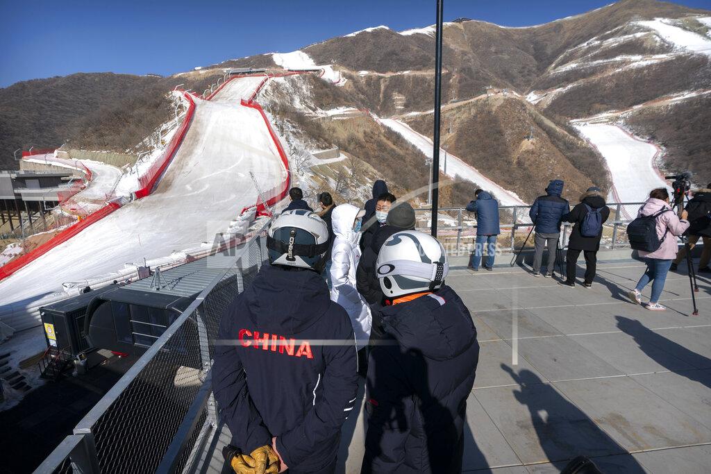 Mark Schiefelbein A skier wearing a China jacket stands at the National Alpine Skiing Center in Yanqing on the outskirts of Beijing, Friday, Feb. 5, 2021. Beijing Olympic organizers showed off the downhill skiing venue and the world's longest bobsled and luge track Friday, one year ahead of the scheduled opening of the 2022 Olympic Winter Games. (AP Photo/Mark Schiefelbein)