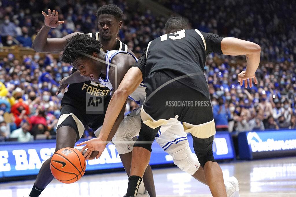 Duke forward AJ Griffin dribbles between Wake Forest forward Khadim Sy and forward Dallas Walton (13) during the second half of an NCAA college basketball game in Durham, N.C., Tuesday, Feb. 15, 2022. (AP Photo/Gerry Broome)