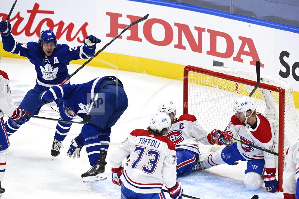 Frank Gunn Toronto Maple Leafs center Auston Matthews (34) celebrates a goal by Zach Hyman, second from left, against the Montreal Canadiens during the second period in Game 5 of an NHL hockey Stanley Cup first-round playoff series in Toronto on Thursday, May 27, 2021. (Frank Gunn/The Canadian Press via AP)