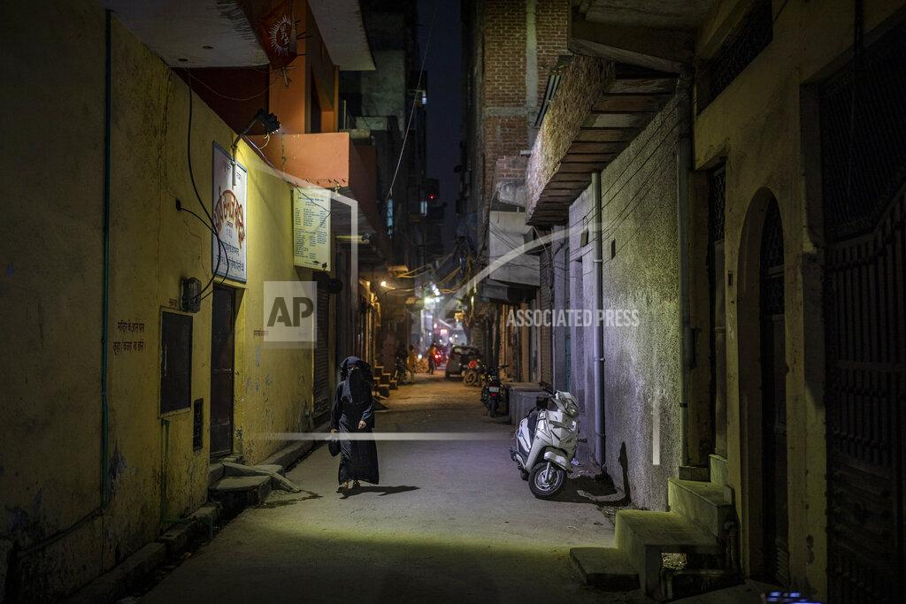 Altaf Qadri A burqa clad Muslim woman walks in an alleyway in North Ghonda neighborhood, one of the worst riot affected area during the February 2020 communal riots, in New Delhi, India, Friday, Feb. 19, 2021. As the first anniversary of bloody communal riots that convulsed the Indian capital approaches, Muslim victims are still shaken and struggling to make sense of their struggle to seek justice. (AP Photo/Altaf Qadri)