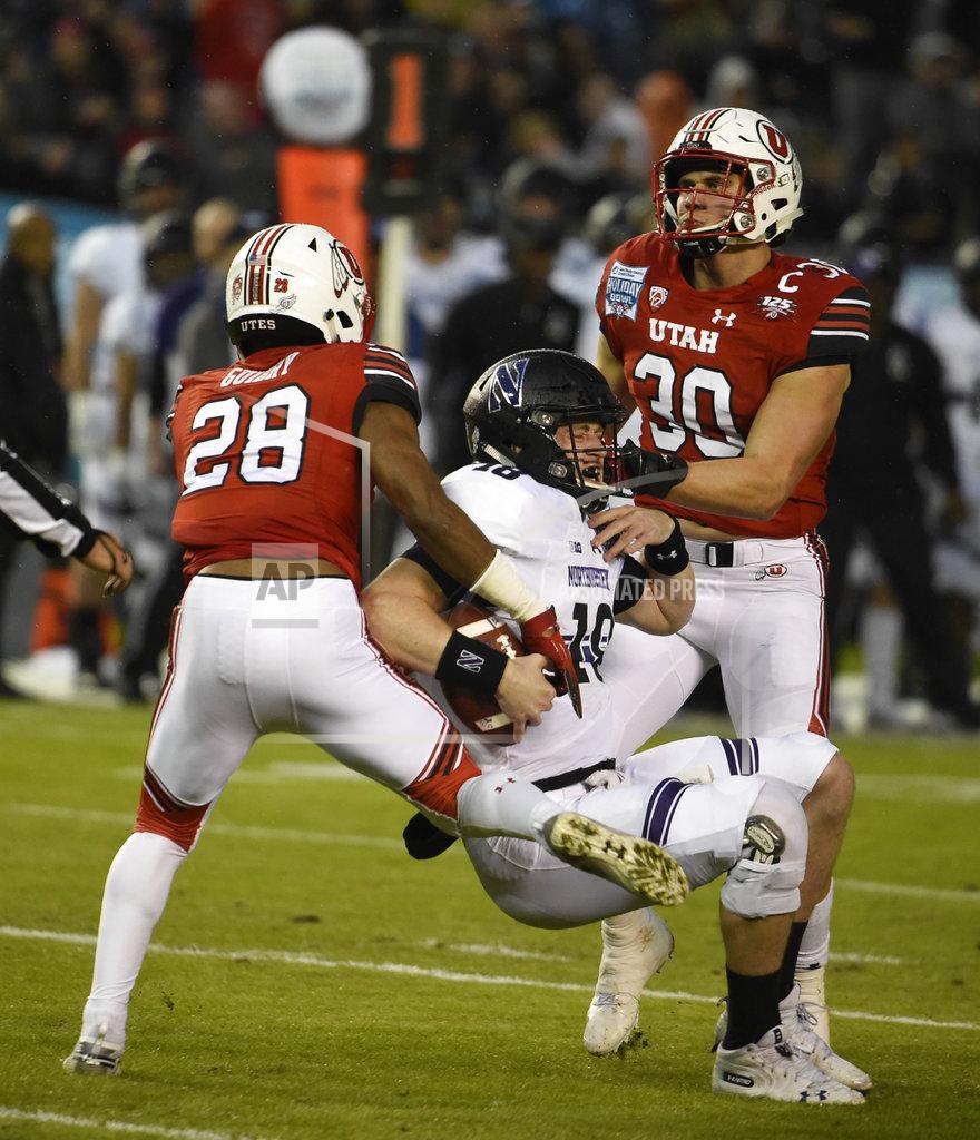 Denis Poroy Northwestern quarterback Clayton Thorson (18) is sacked for a 10-yard loss by Utah defensive back Javelin K. Guidry (28) and linebacker Cody Barton (30) during the first half of the Holiday Bowl NCAA college football game Monday, Dec. 31, 2018, in San Diego. (AP Photo/Denis Poroy)