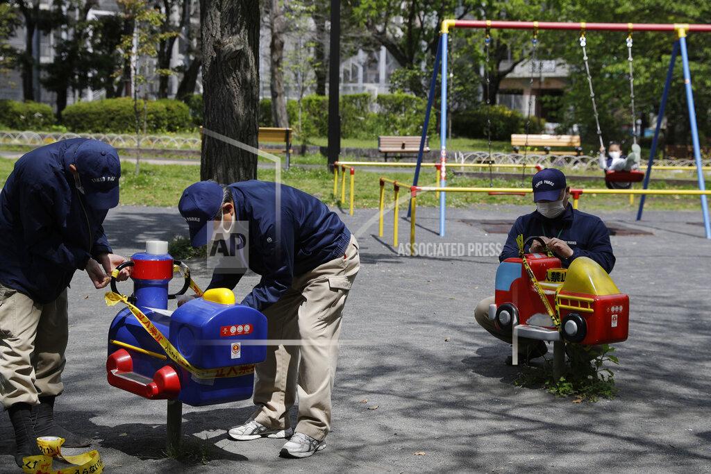 Gregorio Borgia In this April 24, 2020, photo, workers apply ribbon reading, do not enter, as they seal off a playground in Tokyo. Under Japan's coronavirus state of emergency, people have been asked to stay home. Many are not. Some still have to commute to their jobs despite risks of infection, while others are dining out, picnicking in parks and crowding into grocery stores with scant regard for social distancing. (AP Photo/Gregorio Borgia)