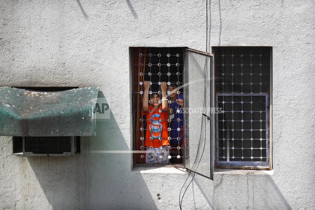 Manish Swarup Uddhav Pratap Sanweria, 8, left, and his older brother Advait Vallabh, 9, play at the window of their home during a nationwide COVID-19 coronavirus lockdown in New Delhi, India, on Tuesday, April 14, 2020. Excited at first about school shutting down indefinitely, the brothers have now started missing being able to go outside. (AP Photo/Manish Swarup)