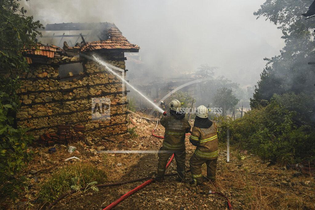 Uncredited Firefighters water to stop a fire in the fire-devastating Sirtkoy village, near Manavgat, Antalya, Turkey, Sunday, Aug. 1, 2021. More than 100 wildfires have been brought under control in Turkey, according to officials. The forestry minister tweeted that five fires are continuing in the tourist destinations of Antalya and Mugla. (AP Photo)