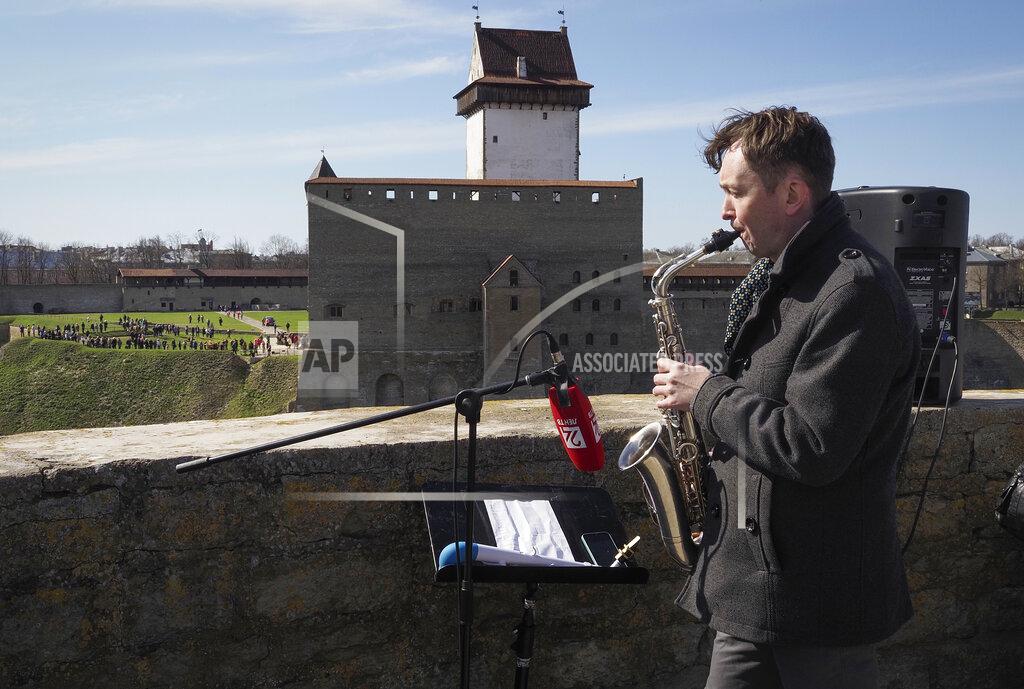 Dmitri Lovetsky Russian saxophonist Alexey Kruglov performs in the Ivangorod Fortress on the Russian-Estonian border in Ivangorod, 130 km (80 miles) west of St.Petersburg, Russia, Friday, April 30, 2021. Musicians on the Estonian-Russian border held an unusual concert on Friday, with Estonian guitarist Jaak Sooaar and Russian saxophonist Alexey Kruglov performing from the castles on the opposing banks of the Narva river that marks the border between the two countries. The concert was held on the International Jazz Day by the two musicians as an act of friendship despite the deteriorating relations between the two countries and as cross-border contacts have been limited due to the corona-virus pandemic. (AP Photo/Dmitri Lovetsky)