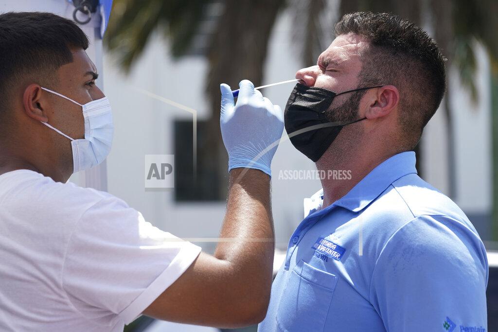 Marta Lavandier EMS technician Emmanuel Orrego, left, administers the COVID-19 PCR test to Yosdany Lugo, Monday, July 26, 2021, in Miami. Florida accounted for a fifth of the nation's new infections last week, more than any other state, according to the CDC. (AP Photo/Marta Lavandier)