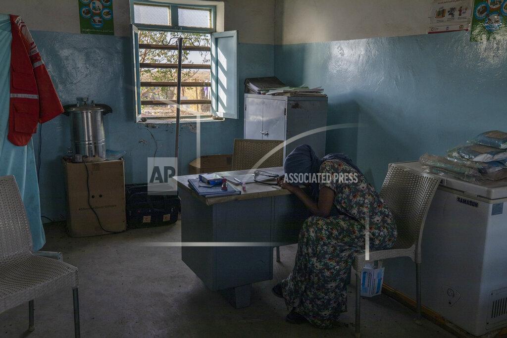 Nariman El-Mofty Tigrayan refugee Hareg, 23, from Mekelle, Ethiopia, reacts after learning of her positive malaria test, administered by surgeon and doctor-turned-refugee, Dr. Tewodros Tefera, at the Sudanese Red Crescent clinic in Hamdayet, eastern Sudan, near the border with Ethiopia, on March 17, 2021. (AP Photo/Nariman El-Mofty)