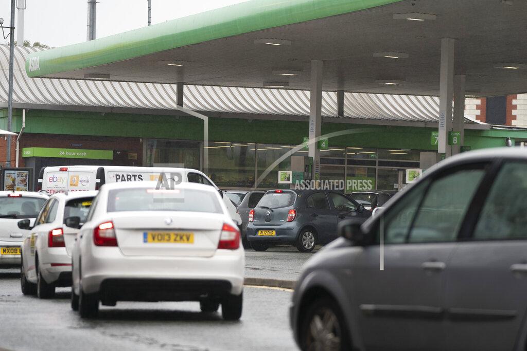 Jon Super Vehicles wait to fill up at a petrol station in Manchester, England, Monday, Sept. 27, 2021. British Prime Minister Boris Johnson is said to be considering whether to call in the army to deliver fuel to petrol stations as pumps ran dry after days of panic buying. ( AP Photo/Jon Super)