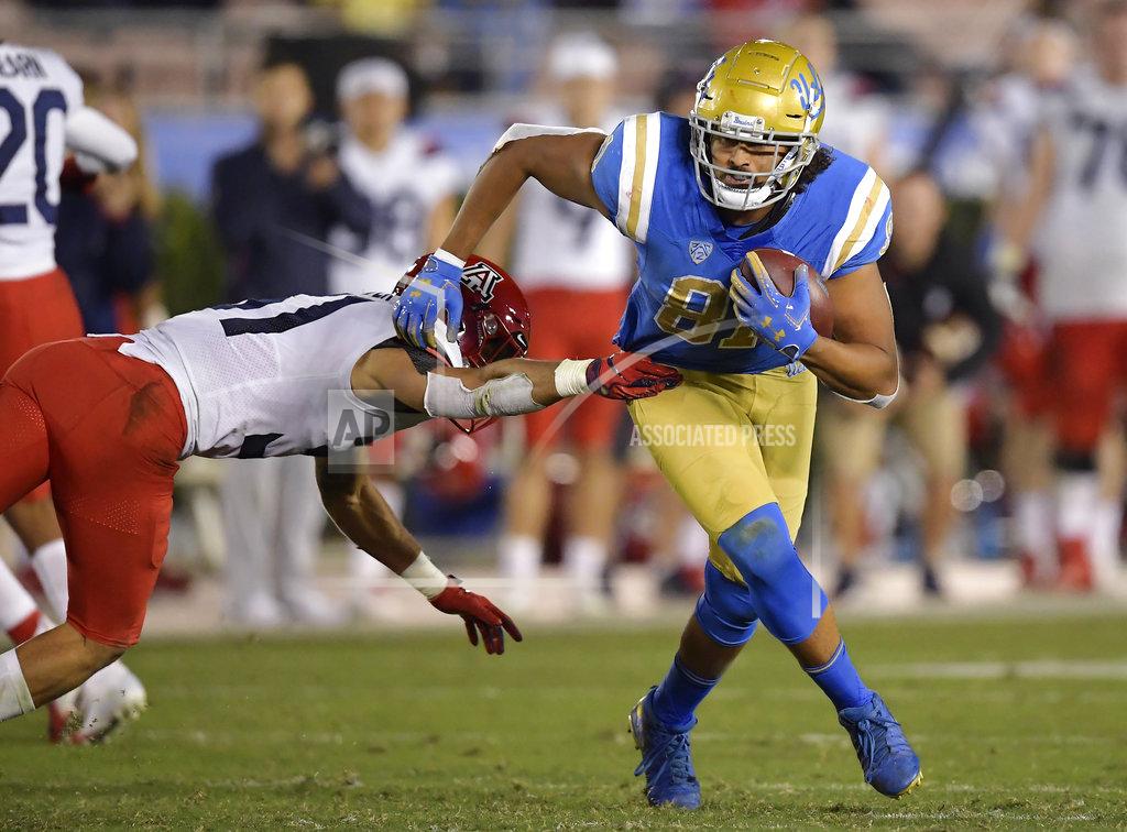 Mark J. Terrill UCLA tight end Caleb Wilson, right, breaks a tackle by Arizona safety Tristan Cooper during the second half of an NCAA college football game Saturday, Oct. 20, 2018, in Pasadena, Calif. UCLA won 31-30. (AP Photo/Mark J. Terrill)