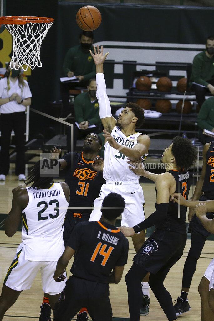 Jerry Larson Baylor guard MaCio Teague (31) scores against Oklahoma State defenders in the second half of an NCAA college basketball game, Thursday, March 4, 2021, in Waco, Texas. (AP Photo/Jerry Larson)
