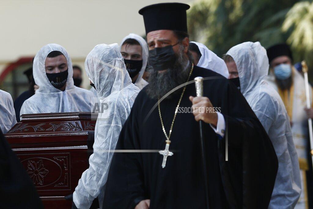 Giannis Papanikos Priests wearing face masks to protect against the spread of the coronavirus, attend the funeral of senior clergyman Ioannis of Lagadas after he died of COVID-19, in Greece's Orthodox Church, in the northern city of Thessaloniki, Greece, Monday, Nov. 16, 2020. Metropolitan Bishop Ioannis of Lagadas, 62, was an outspoken advocate of maintaining communion ceremonies _ at which worshipers are given bread as well as wine with a shared spoon _ during the pandemic, arguing that there was no risk of transmission. (AP Photo/Giannis Papanikos)