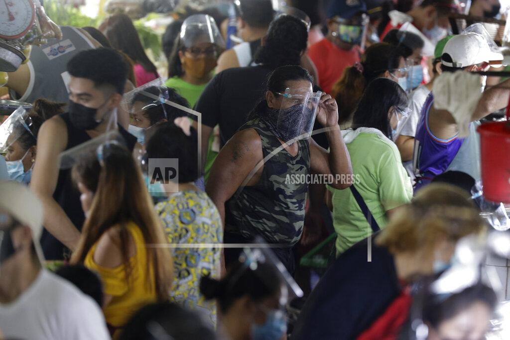 Aaron Favila A man arranges his face shield to prevent the spread of the coronavirus at the Munoz market in Quezon city, Philippines as they prepare for a stricter lockdown on Sunday March 28, 2021. The government will start stricter lockdown measures next week as the country struggles to control an alarming surge in COVID-19 cases. (AP Photo/Aaron Favila)