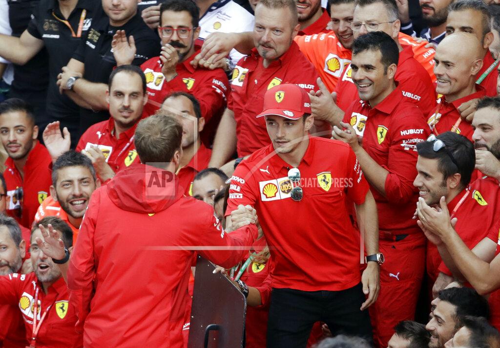 Luca Bruno Ferrari driver Charles Leclerc of Monaco, right, shakes hand with his teammate Sebastian Vettel of Germany as he celebrates after winning the Formula One Italy Grand Prix at the Monza racetrack, in Monza, Italy, Sunday, Sept.8, 2019. (AP Photo/Luca Bruno)