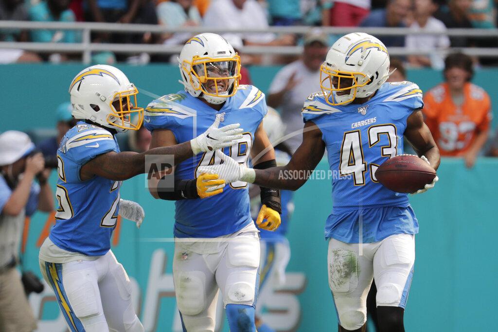 Lynne Sladky Los Angeles Chargers cornerback Casey Hayward (26) and linebacker Drue Tranquill (49), congratulate cornerback Michael Davis (43) after Davis intercepted a pass, during the second half at an NFL football game against the Miami Dolphins, Sunday, Sept. 29, 2019, in Miami Gardens, Fla. The Chargers defeated the Dolphins 30-10. (AP Photo/Lynne Sladky)