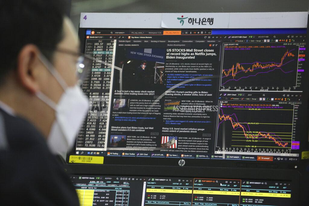 Ahn Young-Joon A screen shows a news report about U.S. President Joe Biden's inauguration as a currency trader works at the foreign exchange dealing room of the KEB Hana Bank headquarters in Seoul, South Korea, Thursday, Jan. 21, 2021. (AP Photo/Ahn Young-joon)