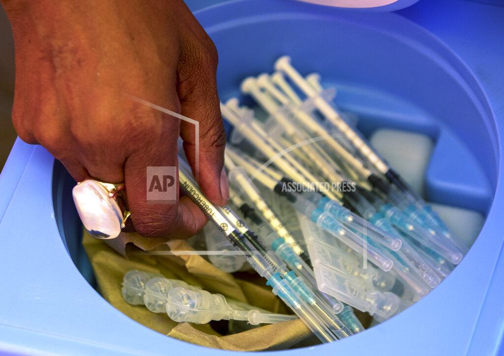 Themba Hadebe FILE - In this Tuesday, May 25, 2021 file photo, a health worker picks syringes as seniors get vaccinated with the first dose of the Pfizer coronavirus vaccine at the newly-opened mass vaccination program for the elderly at a drive-thru vaccination center in Johannesburg, South Africa. African health officials and the United Nations warned Thursday, Oct. 28, 2021 of a looming shortage of up to 2 billion syringes for mainly low- and middle-income countries around the world. (AP Photo/Themba Hadebe, File)