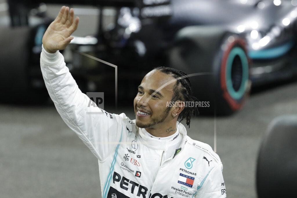 Luca Bruno Mercedes driver Lewis Hamilton of Britain celebrates pole position during the qualifying session at the Yas Marina racetrack in Abu Dhabi, United Arab Emirates, Saturday, Nov. 30, 2019. The Emirates Formula One Grand Prix will take place on Sunday. (AP Photo/Luca Bruno)
