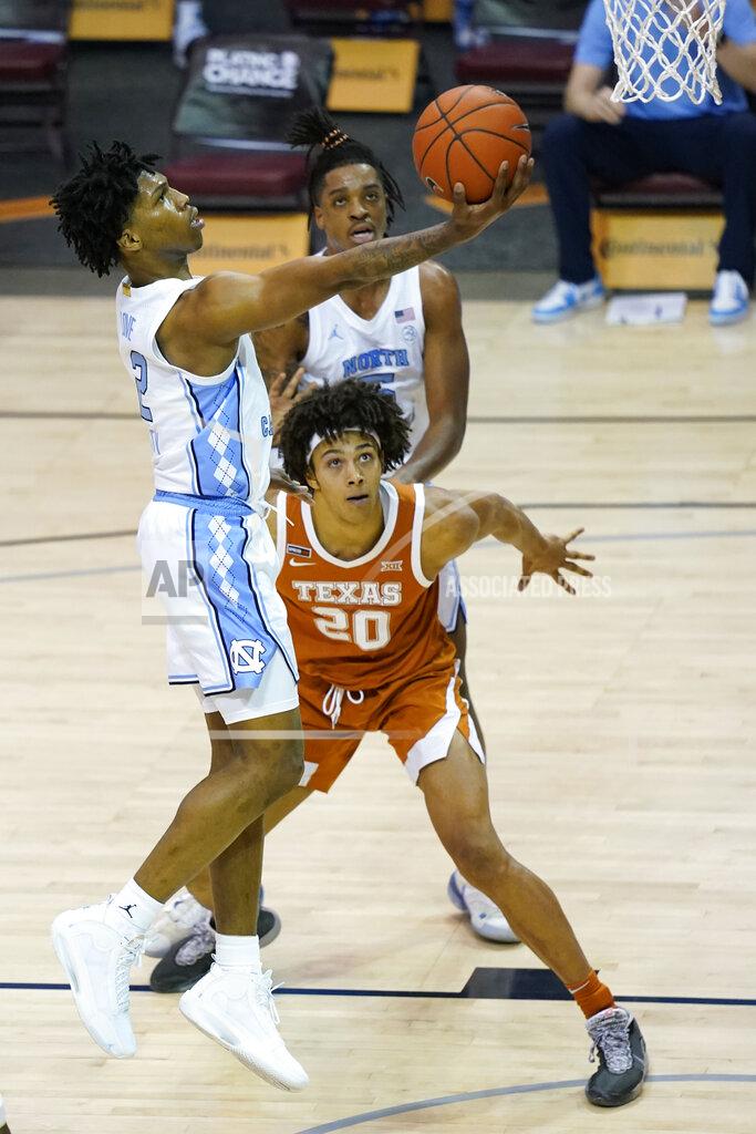 Kathy Kmonicek North Carolina guard Caleb Love (2) leaps to the basket over Texas forward Jericho Sims (20) in the second half of an NCAA college basketball game for the championship of the Maui Invitational, Wednesday, Dec. 2, 2020, in Asheville, N.C. Texas won 69-67. (AP Photo/Kathy Kmonicek)