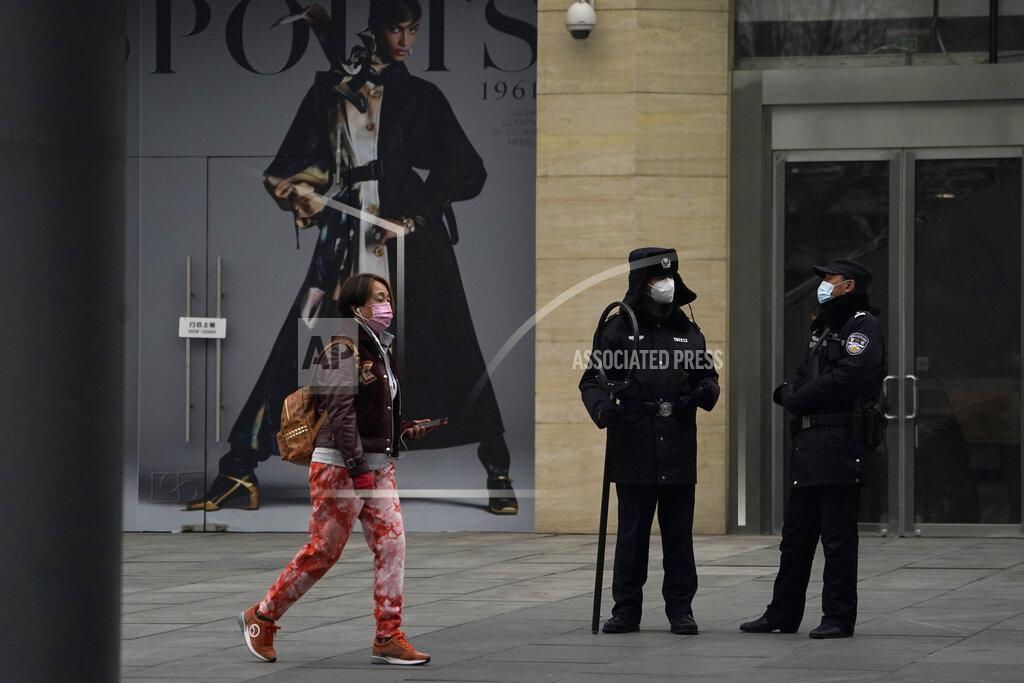 Ng Han Guan Security personnel watch over a retail street in Beijing Wednesday, March 3, 2021. The state of the world's second largest economy takes precedence among the myriad issues presented by Chinese Premier Li Keqiang in his address at the National People's Congress opening session to take place on Friday, March 5. 2021. (AP Photo/Ng Han Guan)