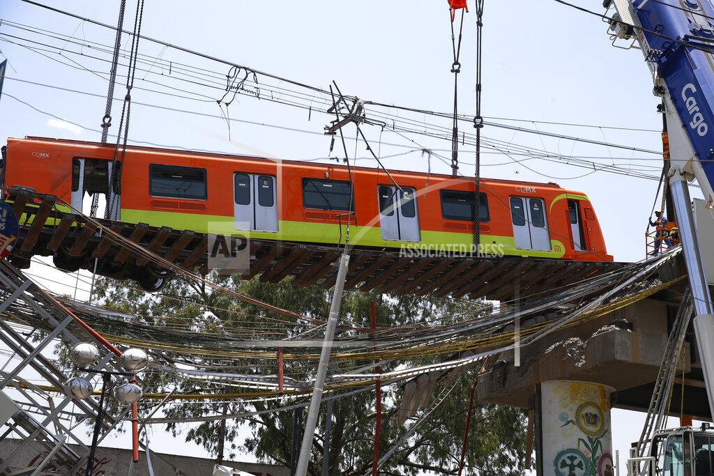 Marco Ugarte A subway car is prepared to be lowered to the ground, with the help of a crane, from a collapsed elevated section of the metro, in Mexico City, Tuesday, May 4, 2021. The elevated section of the Line 12 metro collapsed late Monday, killing at least 23 people and injuring at least 79, city officials said. (AP Photo/Marco Ugarte)