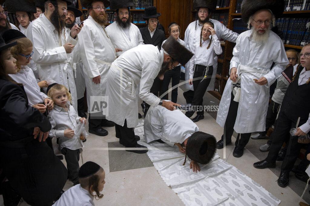 Oded Balilty An ultra-Orthodox Jewish man whips a member of his Hasidic dynasty with a leather strap as a symbolic punishment for his sins last year, during the traditional Malkot (whipping in Hebrew) ceremony, ahead of Yom Kippur that begins at sunset, in the city of Beit Shemesh, near Jerusalem, Wednesday, Sept. 15, 2021. Yom Kippur is Judaism's day of atonement, when devout Jews ask God to forgive them for their transgressions and refrain from eating and drinking, attending intense prayer services in synagogues. (AP Photo/Oded Balilty)