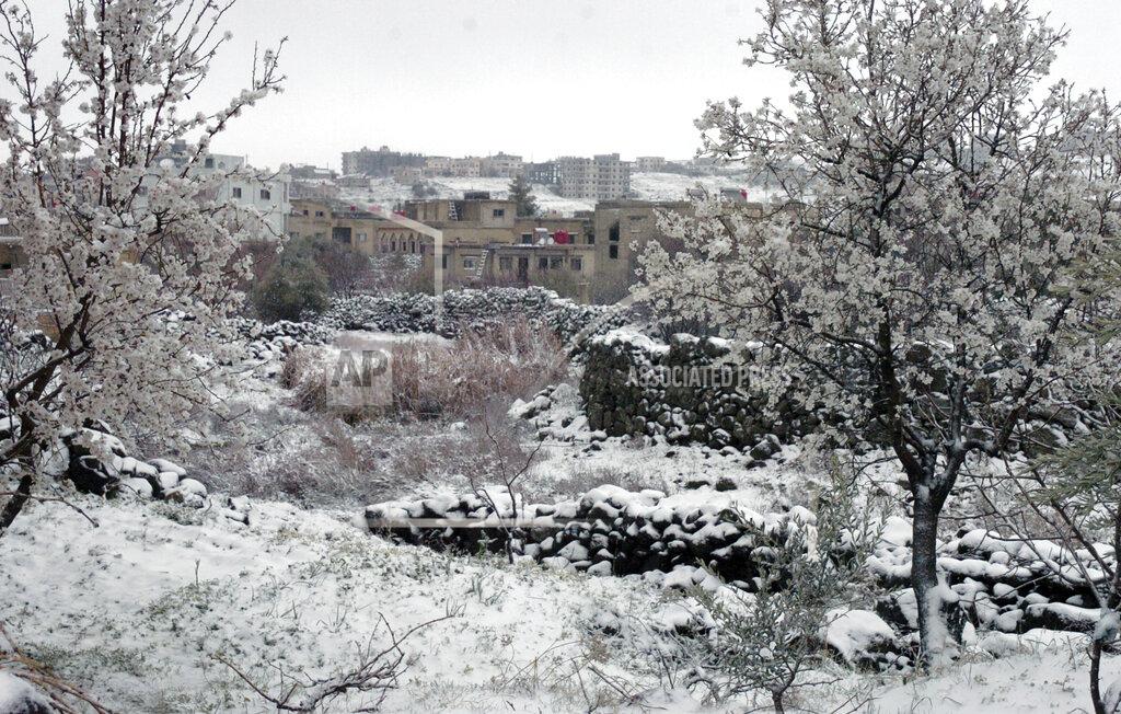 Uncredited In this photo released by the Syrian official news agency SANA, snow covers a village in the southern province of Sweida, Syria. Wednesday, Feb. 17, 2021. Snow blanketed parts of Syria, Lebanon, Jordan and Israel on Wednesday, blocking roads, disrupting traffic and postponing vaccination campaigns against COVID-19 and even exams at some universities. (SANA via AP)