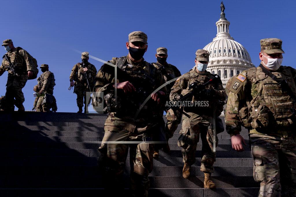 Members of the National Guard walk past the Dome of the Capitol Building on Capitol Hill in Washington, Thursday, Jan. 14, 2021. (AP Photo/Andrew Harnik)