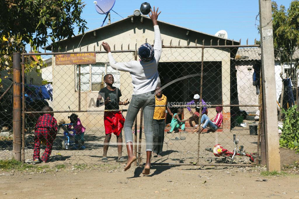 Tsvangirayi Mukwazhi Children play with a ball outside a house, in Harare, Friday, July, 31, 2020. Zimbabwe's capital, Harare, was deserted Friday, as security agents vigorously enforced the country's lockdown amidst planned protests. Police and soldiers manned checkpoints and ordered people seeking to get into the city for work and other chores to return home. (AP Photo/Tsvangirayi Mukwazhi)