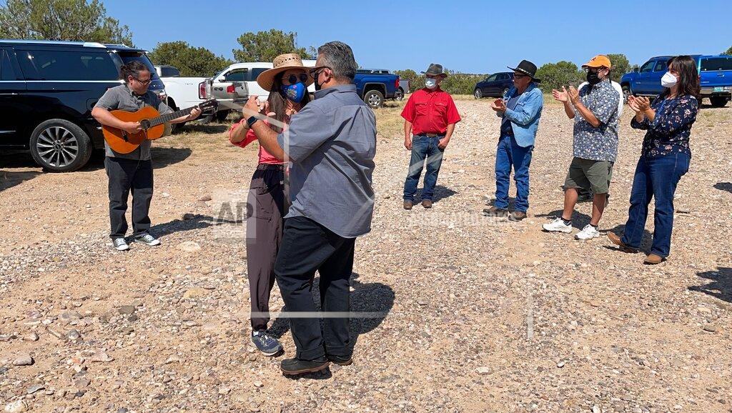 Susan Montoya Bryan This Aug. 31, 2021 photo shows U.S. Rep. Teresa Leger Fernández dancing with state Sen. Leo Jaramillo near Abiquiu, New Mexico, as David García, left, plays a corrido, or folk song, about the traditional irrigation systems known as acequias. The systems are facing more pressure amid drought and warmer temperatures. (AP Photo/Susan Montoya Bryan)
