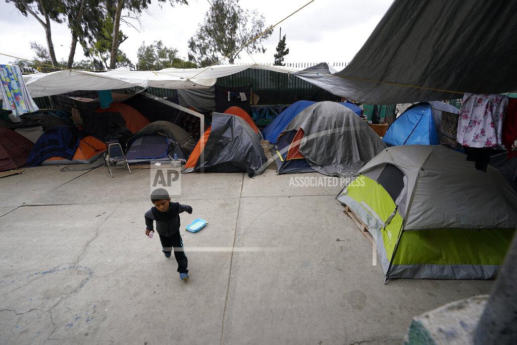 Gregory Bull A boy from Honduras runs past tents set up at a shelter for migrants Friday, May 20, 2022, in Tijuana, Mexico. (AP Photo/Gregory Bull)