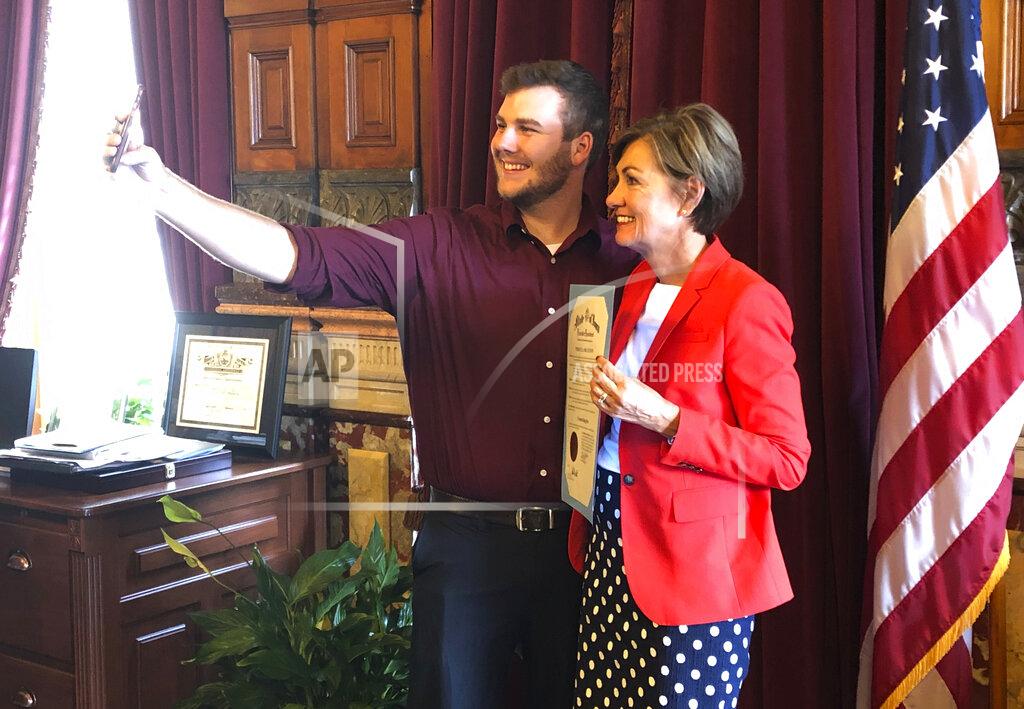 David Pitt Carson King, of Altoona, Iowa, snaps a selfie Wednesday, Sept. 25, 2019, in the Iowa State Capitol in Des Moines, Iowa, with Iowa Gov. Kim Reynolds, who holds a proclamation declaring Saturday as Carson King Day. The honor was to mark King’s plans to donate more than $1 million to charity after his decision to display a hand-written sign before the Sept. 14 Iowa State-Iowa football game seeking money for beer prompted an overwhelming number of donations. (AP Photo/David Pitt)
