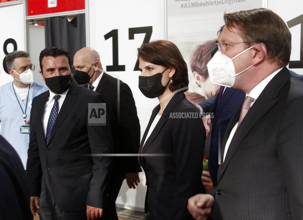 Boris Grdanoski European Commissioner for Neighborhood and Enlargement Oliver Varhelyi, right, Austrian Federal Minister for EU Karoline Edstadler, center, and North Macedonia's Prime Minister Zoran Zaev visit the center for mass vaccination against COVID-19, at A1 Arena in Skopje, North Macedonia, on Tuesday, May 4, 2021. The European Union started delivering EU-funded coronavirus vaccines Tuesday to the Balkans, a region that wants to join the 27-nation bloc but where China and Russia have already been supplying the much-needed shots and making political gains. (AP Photo/Boris Grdanoski)