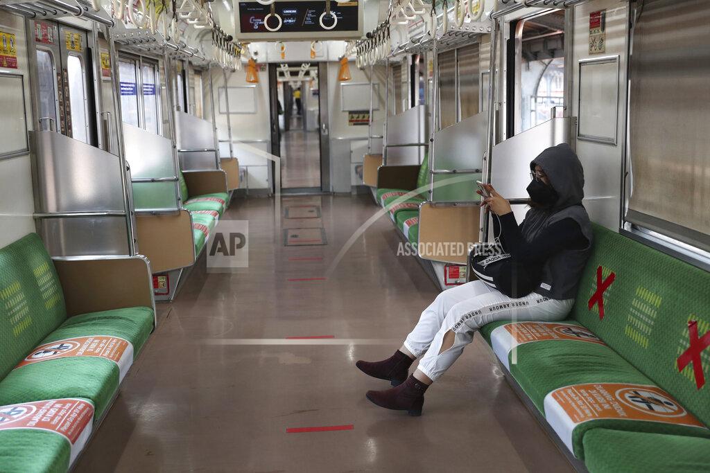 Tatan Syuflana A woman wearing a face mask to curb the spread of coronavirus sits inside an empty train at the Jakarta Kota train station in Jakarta, Indonesia, Wednesday, July 28. (AP Photo/Tatan Syuflana)