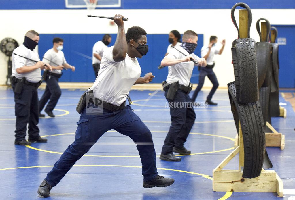 Steve Ruark Baltimore city police trainee Alhaji Fofana, of Philadelphia, uses a baton during defense tactic training, Wednesday, Aug. 4, 2021, in Baltimore. Baltimore's police force is struggling to meet staffing targets to fully comply with a reform intervention and get out from under federal oversight. The agency has some 400 vacancies among its sworn staff and its recruitment efforts just can’t keep pace with those leaving their jobs.(AP Photo/Steve Ruark)