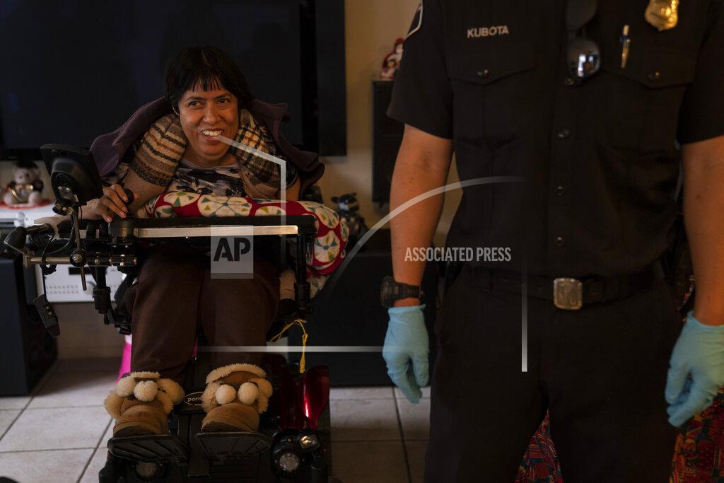 Jae C. Hong Barbara Franco, who has muscular dystrophy, smiles while talking to Torrance firefighters after receiving the second dose of the Pfizer COVID-19 vaccine at her apartment, Wednesday, May 12, 2021, in Torrance, Calif. Teamed up with the Torrance Fire Department, Torrance Memorial Medical Center started inoculating people at home in March, identifying people through a city hotline, county health department, senior centers and doctor's offices, said Mei Tsai, the pharmacist who coordinates the program. (AP Photo/Jae C. Hong)