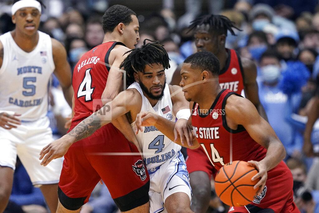 Gerry Broome North Carolina State guard Casey Morsell (14) dribbles while forward Jericole Hellems (4) blocks North Carolina guard R.J. Davis (4) during the first half of an NCAA college basketball game in Chapel Hill, N.C., Saturday, Jan. 29, 2022. (AP Photo/Gerry Broome)