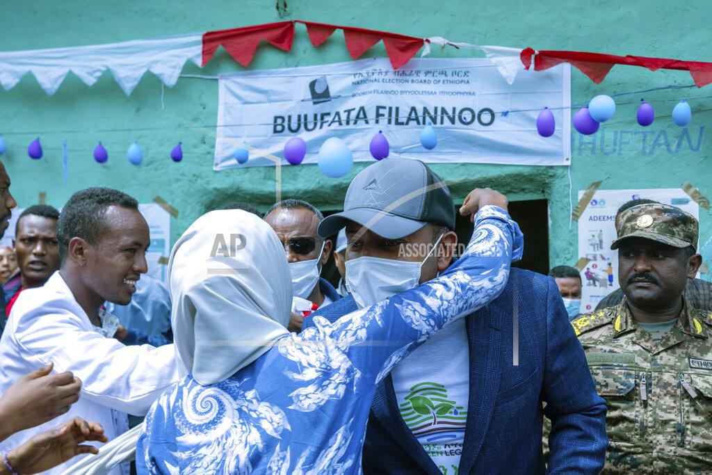 Mulugeta Ayene Ethiopia's Prime Minister Abiy Ahmed, centre, is hugged by a supporter, after casting his vote in the general election in his home town of Beshasha, in the Oromia region of Ethiopia Monday, June 21, 2021. Ethiopia began voting in the greatest electoral test yet for Prime Minister Abiy Ahmed as war and logistical issues mean ballots won’t be cast in more than 100 of the 547 constituenciesacross the country. The election is the centerpiece of a reform drive by Abiy, whose rise to power in 2018 seemed to signal a break with decades of authoritarian rule and led to him winning a Nobel Peace Prize. (AP Photo/Mulugeta Ayene)