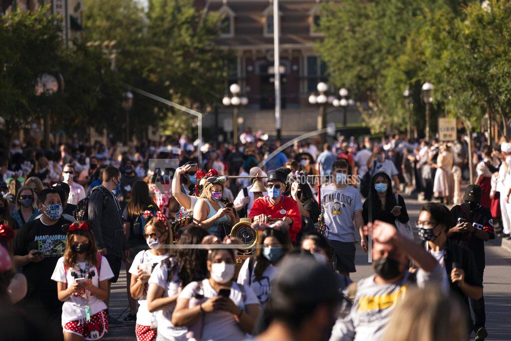 Jae C. Hong Visitors walk along the Main Street USA at Disneyland in Anaheim, Calif., Friday, April 30, 2021. The iconic theme park in Southern California that was closed under the state's strict virus rules swung open its gates Friday and some visitors came in cheering and screaming with happiness. (AP Photo/Jae C. Hong)