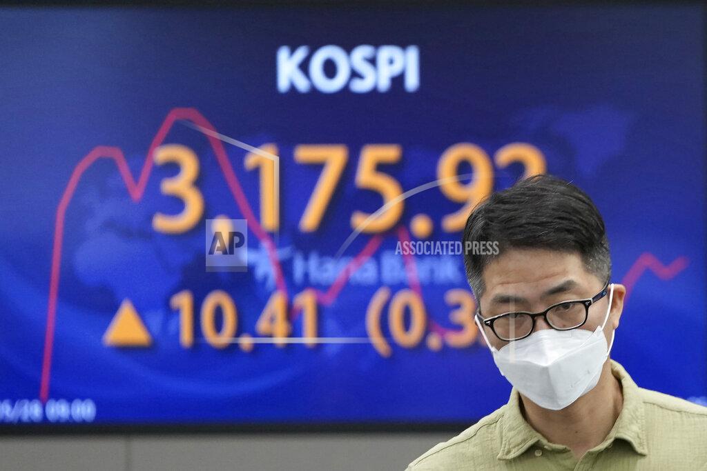 A currency trader walks near the screen showing the Korea Composite Stock Price Index (KOSPI) at the foreign exchange dealing room in Seoul, South Korea, Friday, May 28, 2021. Asian shares rose Friday, powered by encouraging signs that the U.S. economic recovery from the pandemic is gaining momentum. (AP Photo/Lee Jin-man)