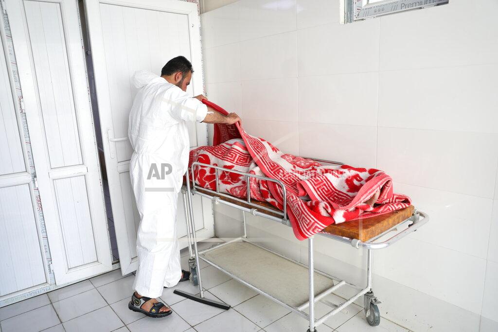 Rahmat Gul An Afghan health worker checks the body of a woman who died from COVID-19 at the Afghan-Japan Communicable Disease Hospital in Kabul, Afghanistan, Sunday, May 30, 2021. Afghanistan is battling a brutal third wave of COVID infections, while health officials plead for vaccines, expressing deep frustration at the inequities of the global vaccine distribution. Positive COVID cases jump from eight percent to 60 per cent in some parts of the country. (AP Photo/Rahmat Gul)