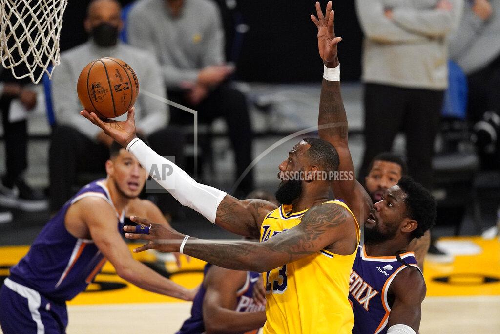 Mark J. Terrill Los Angeles Lakers forward LeBron James, left, shoots as Phoenix Suns center Deandre Ayton defends during the second half of an NBA basketball game Tuesday, March 2, 2021, in Los Angeles. (AP Photo/Mark J. Terrill)